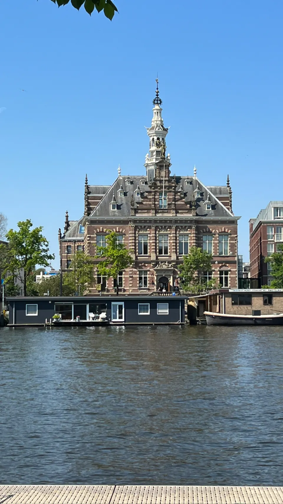 A historic building with a clock tower across the water