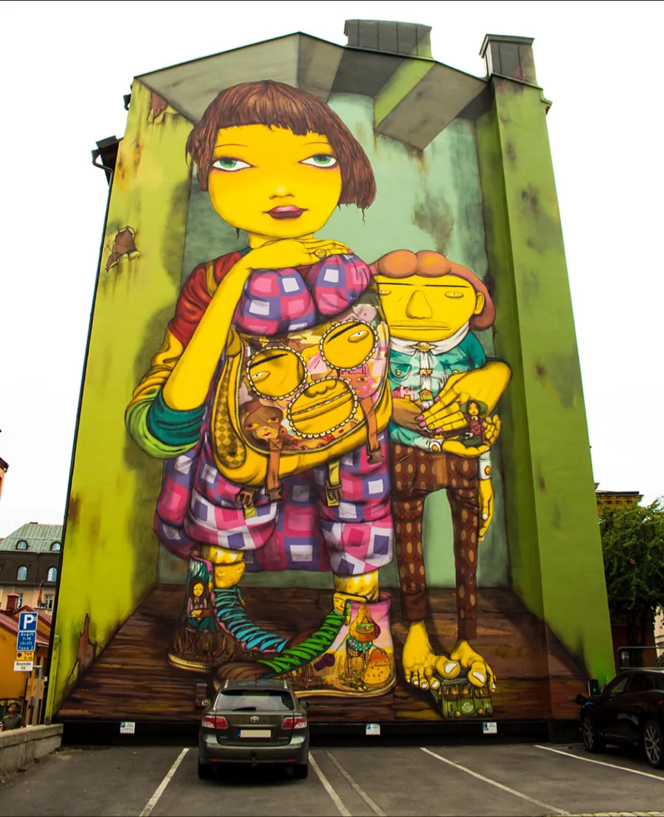Mural of a figure in yellow on the side of a building