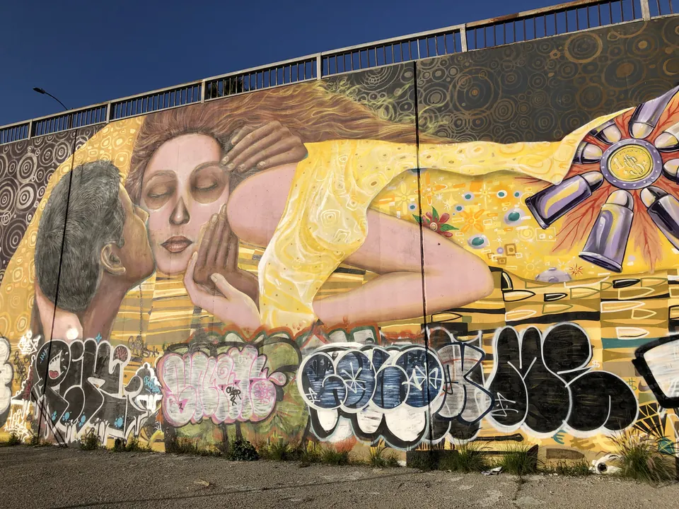 Mural of a reclining woman above a graffiti wall