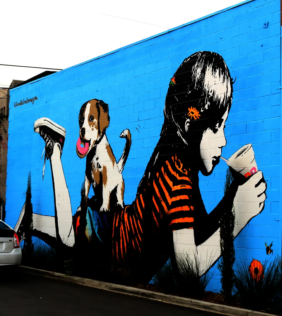 Mural of a girl and a dog on a blue wall