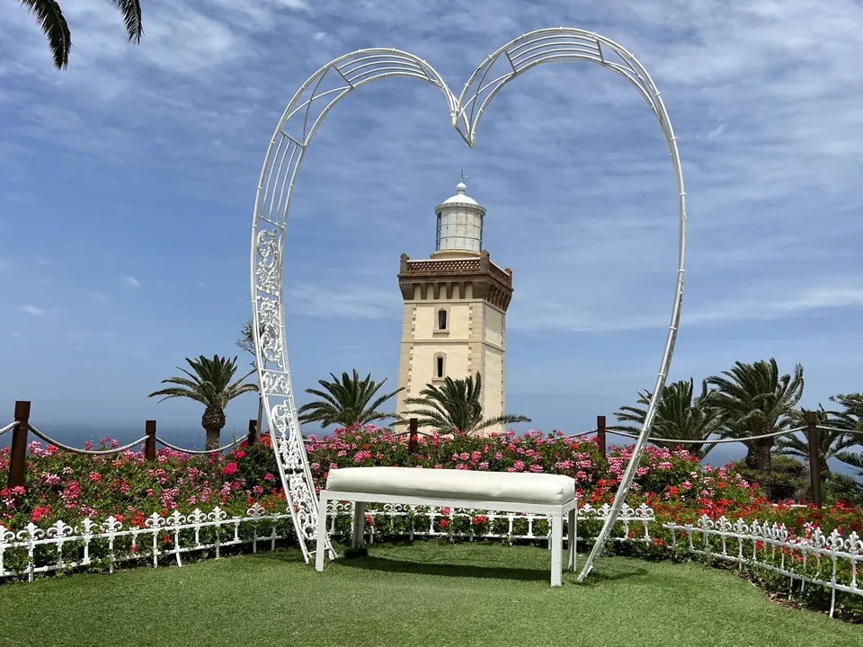 A lighthouse framed by a white heart arch
