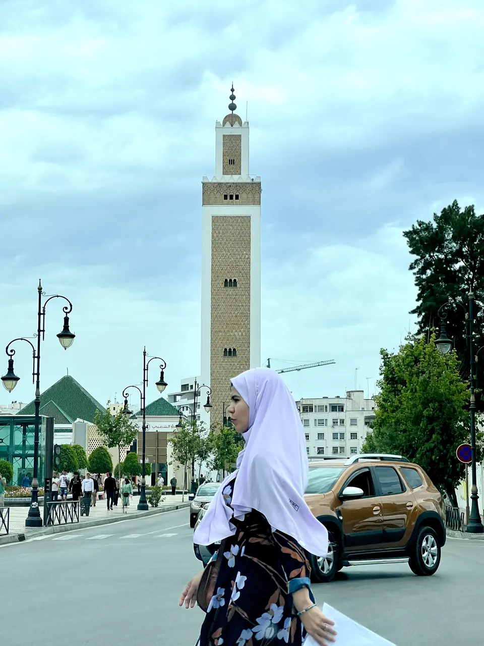 A street with a minaret and palm trees