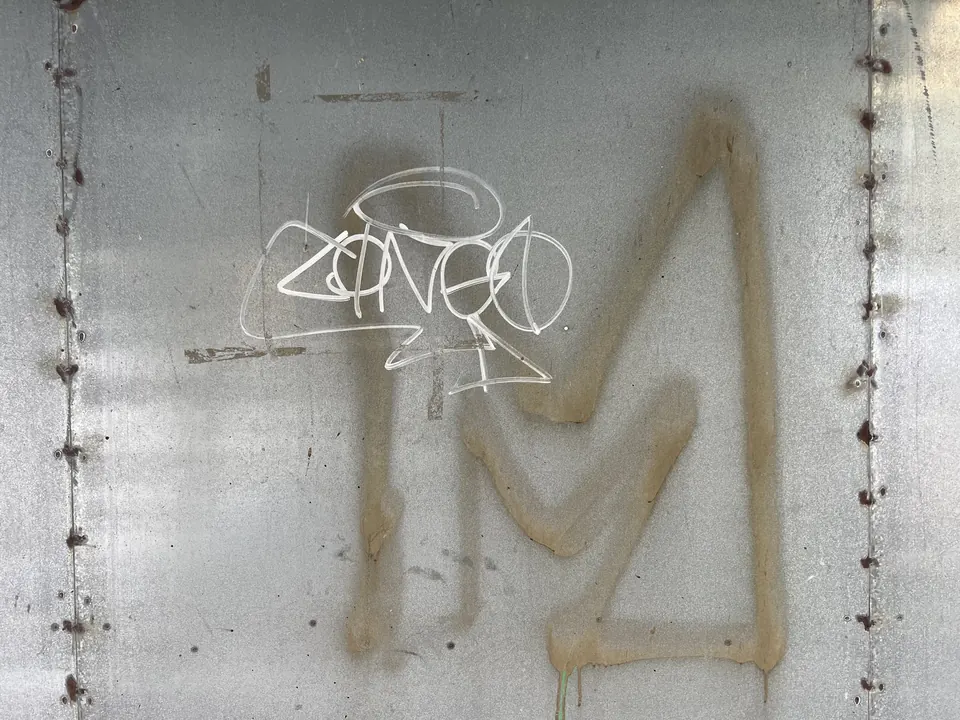 A graffiti tag on a steel wall