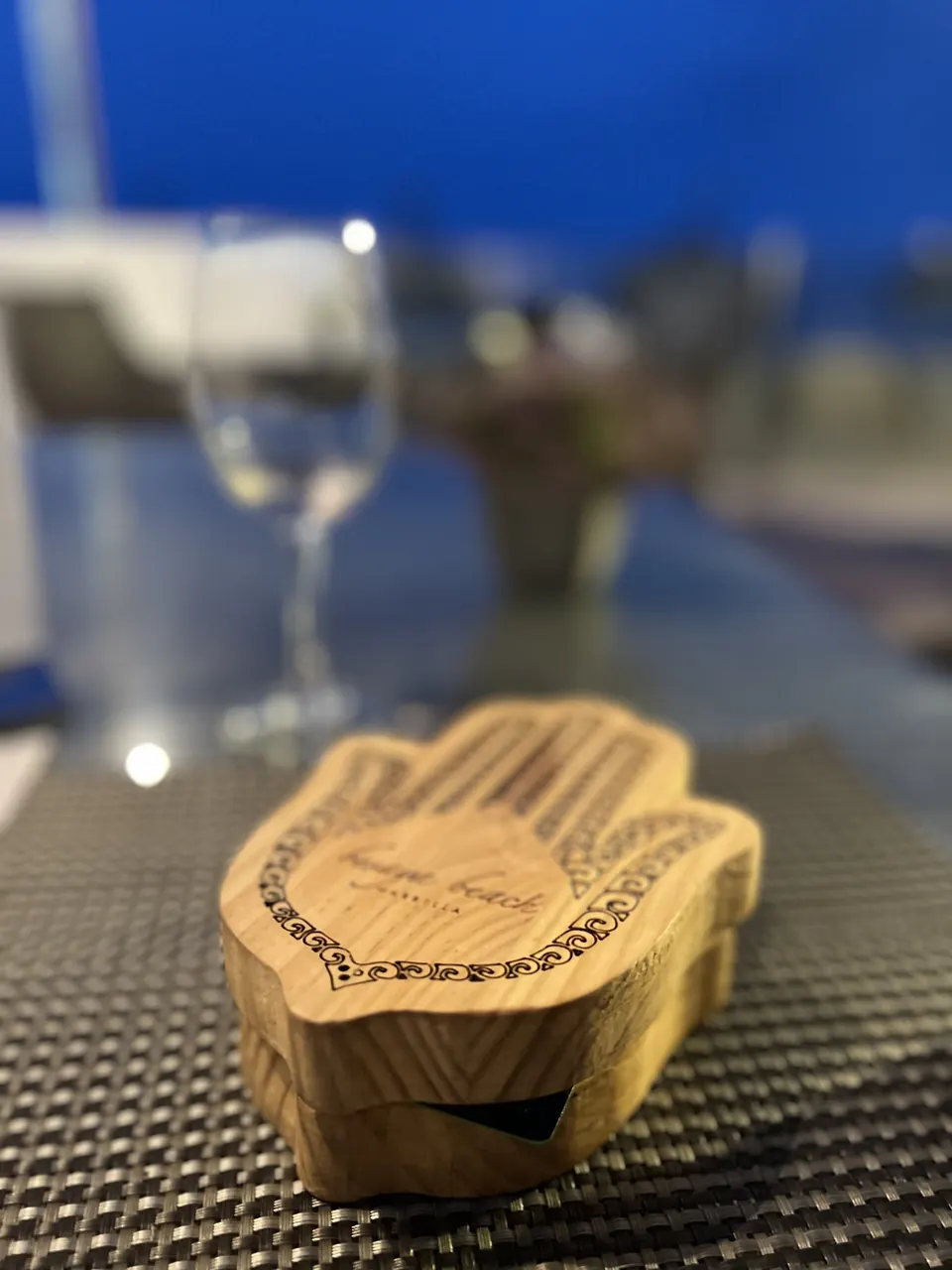 A carved wooden hand of Fatima on a table