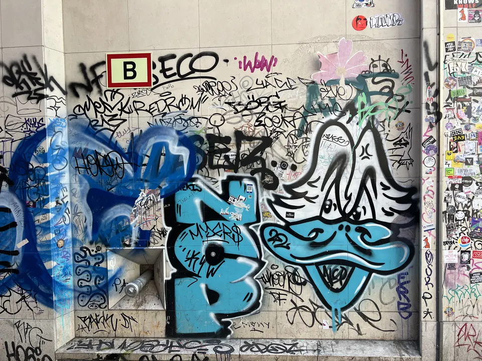 A wall covered in graffiti and stickers