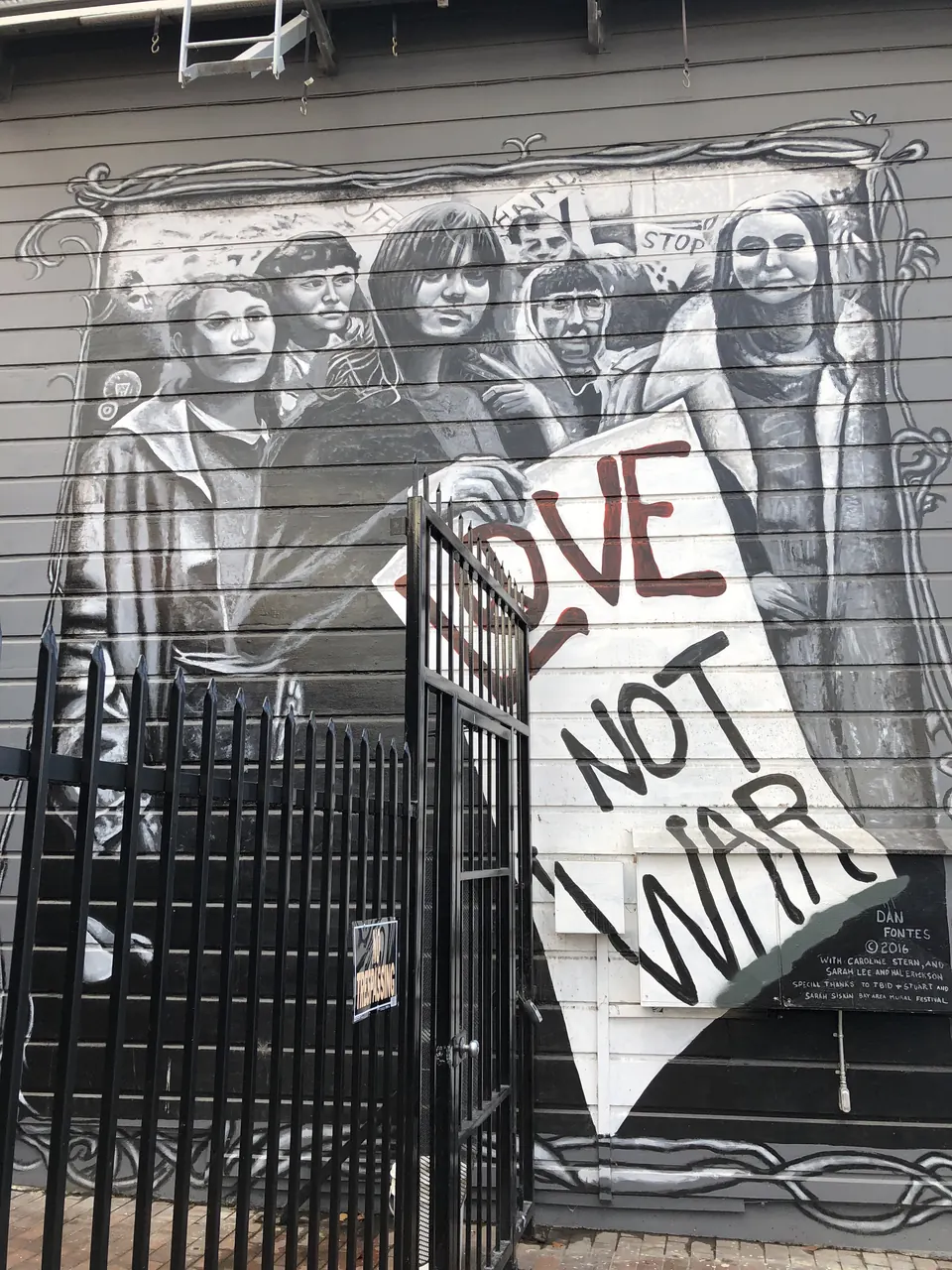 Black and white mural with a Love Not War sign